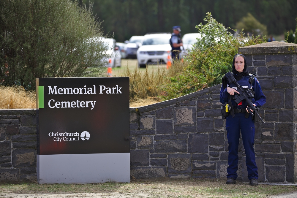 A police officer stands guard as relatives of victims of mosque attack arrive to attend the funeral of a victim who died at the mosque attack at Memorial Park Cemetery, in Christchurch, New Zealand on March 21, 2019.  Peter Adones - Anadolu