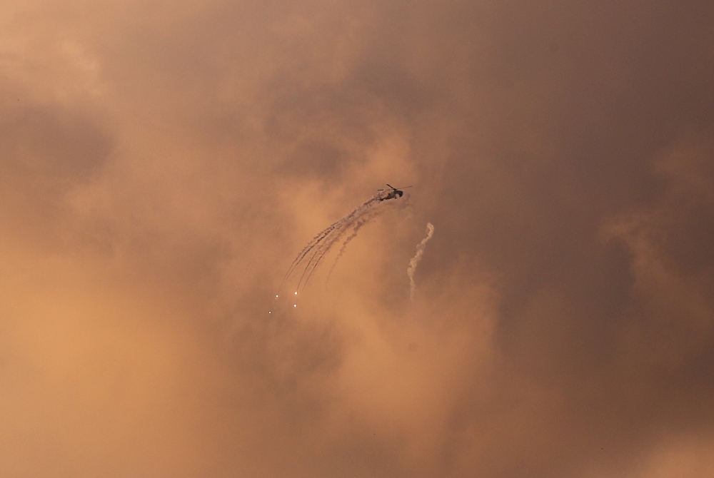 An Israeli Apache helicopter releases flares as it flies over the Gaza Strip March 25, 2019. Reuters/Mohammed Salem