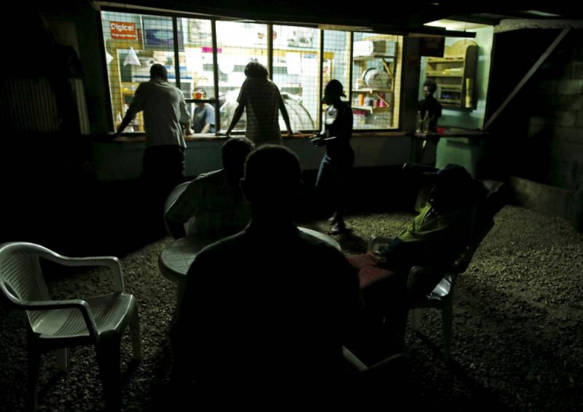 People sit at a kava bar operating with limited electricity days after Cyclone Pam in Port Vila, capital city of the Pacific island nation of Vanuatu March 19, 2015. Reuters/Edgar Su