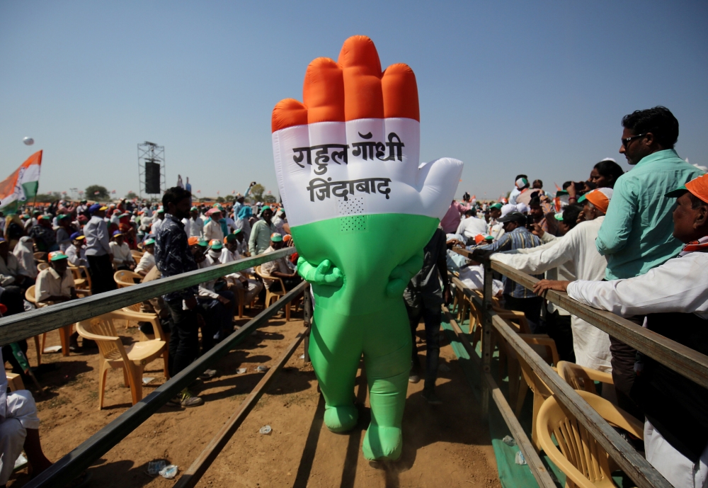 A supporter wearing an inflatable symbol of India's main opposition Congress party walks during a public meeting in Gandhinagar, Gujarat, India, March 12, 2019. The words read: 