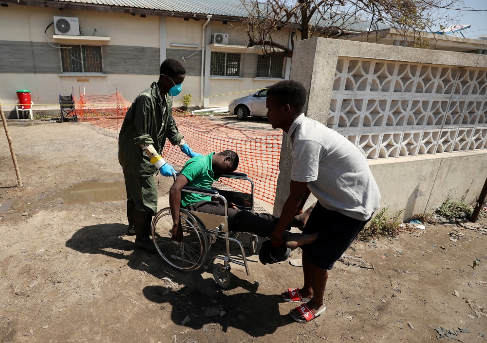 A medical staff member assists a man arriving at a cholera treatment centre set up in the aftermath of Cyclone Idai in Beira, Mozambique, March 29, 2019. Reuters/Mike Hutchings