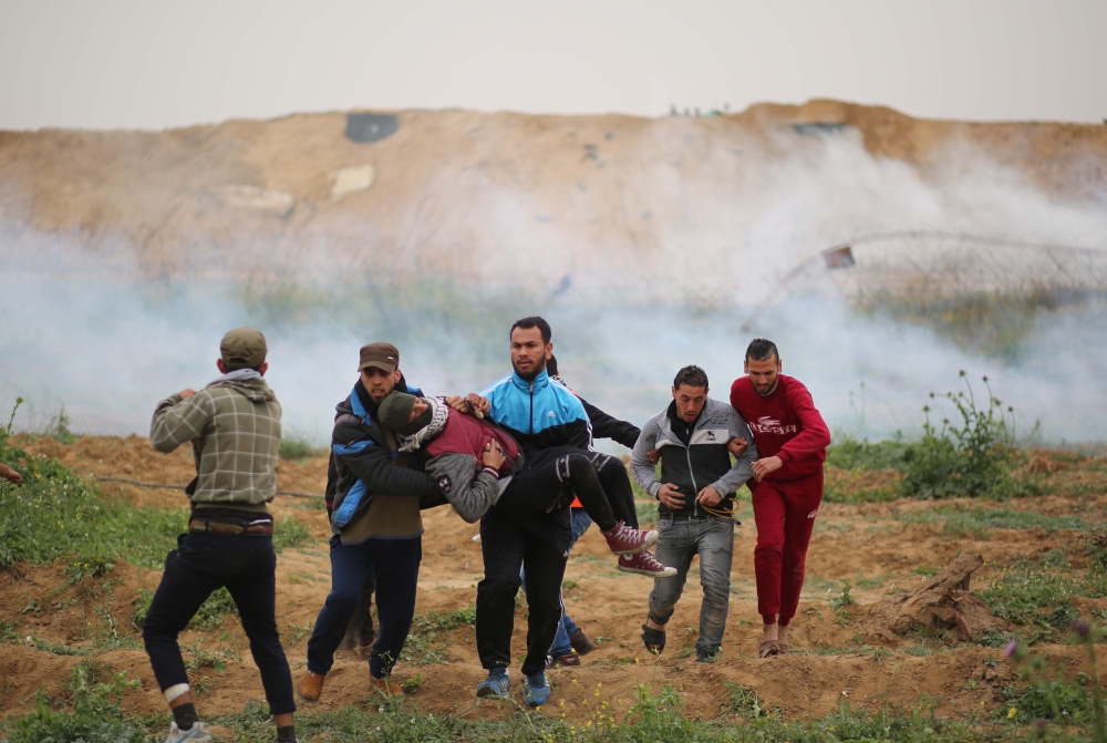 An injured Palestinian is carried away during a protest within the 