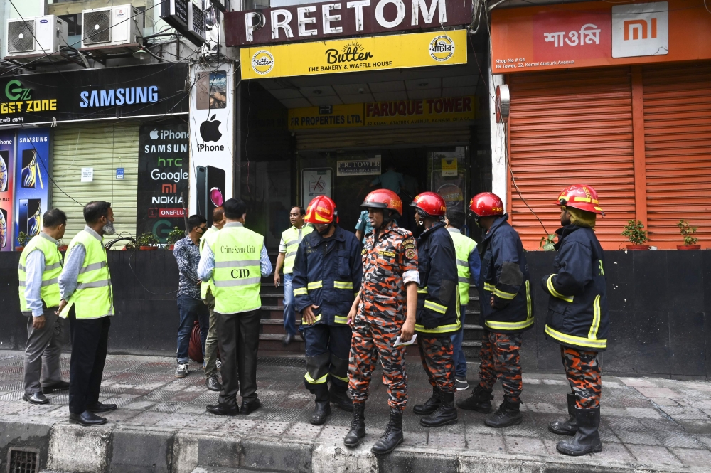Bangladeshi forensic experts work at the scene of the burnt building along with firefighters in Dhaka on March 29, 2019, a day after flames tore through the 22-storey FR Tower. AFP/Munir Uz Zaman 