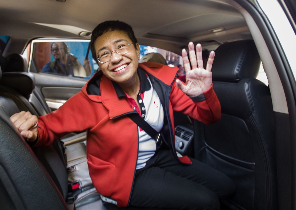Philippine journalist Maria Ressa waves to photographers after posting bail outside a court building in Manila on March 29, 2019.  AFP / Maria Tan 