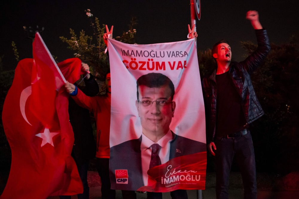 Supporters of the main opposition Republican People's Party (CHP) unfurl a portrait of candidate Ekrem Imamoglu to celebrate local election in Istanbul, Turkey on 1 April 2019. AFP / Yasin AKGUL