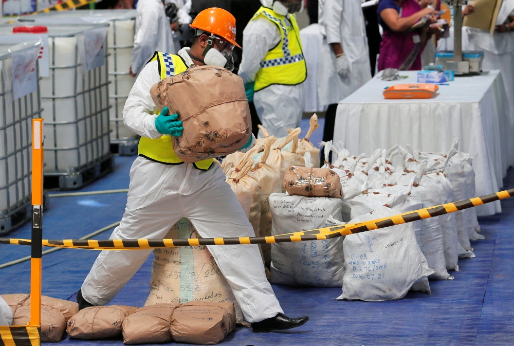 A Sri Lankan police narcotic bureau officer places a haul of seized cocaine sacks to be destroyed under judicial supervision in Colombo, Sri Lanka April 1, 2019. REUTERS/Dinuka Liyanawatte