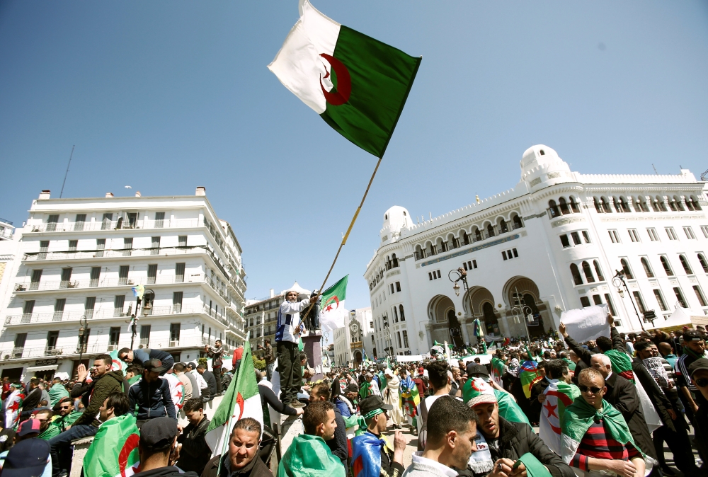 People carry national flags during a protest to demand the removal of President Abdelaziz Bouteflika in Algiers, Algeria March 29, 2019. Reuters/Ramzi Boudina 