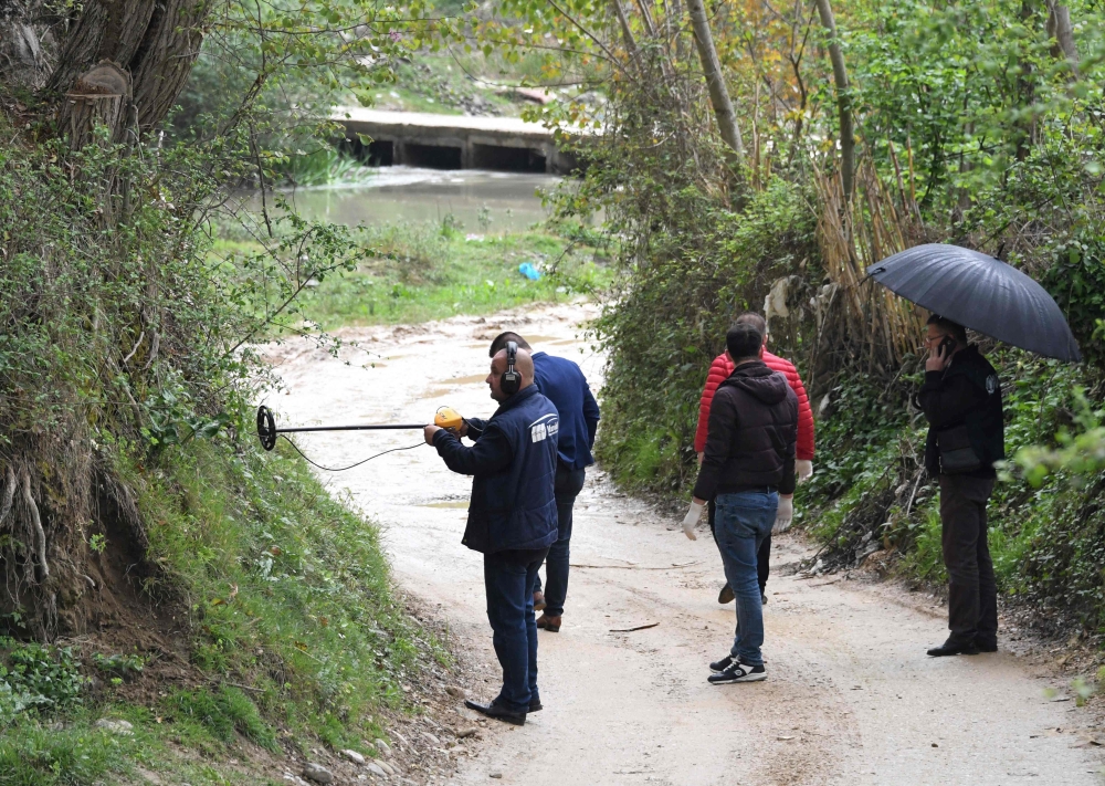 Forensic experts search for evidence near the village of Rinas, near Tirana, on April 10, 2019, at the place where police clashed with armed robbers who stole millions of euros from an Austria Airlines aeroplane in a deadly heist. AFP / Gent Shkullaku 