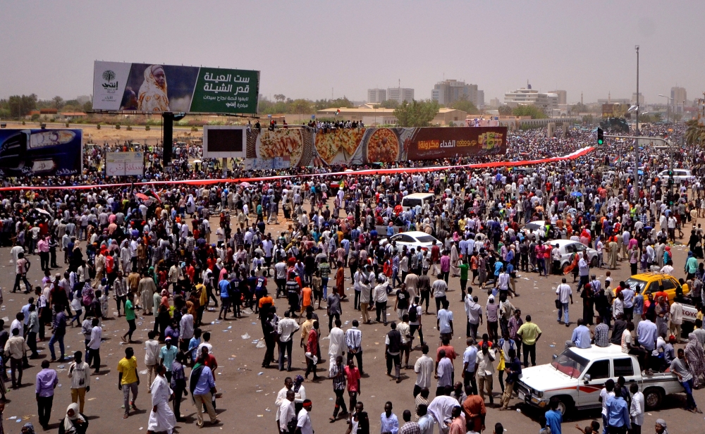 Sudanese demonstrators gather after Sudan's Defense Minister Awad Mohamed Ahmed Ibn Auf said that President Omar al-Bashir had been detained 