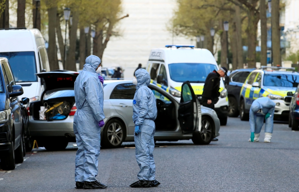 Police forensics officers work at the site where police fired shots after a vehicle rammed the parked car of Ukraine's ambassador, outside the Ukrainian embassy in London, Britain, April 13, 2019. REUTERS/Gonzalo Fuentes