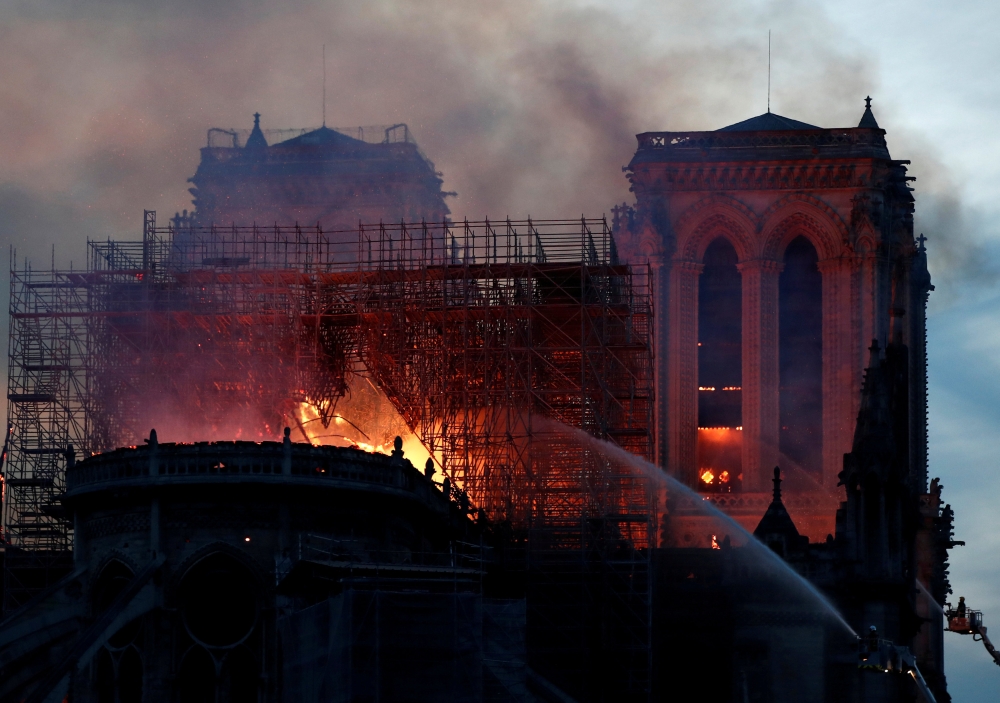 Fire fighters douse flames of the burning Notre Dame Cathedral in Paris, France April 15, 2019. REUTERS/Benoit Tessier