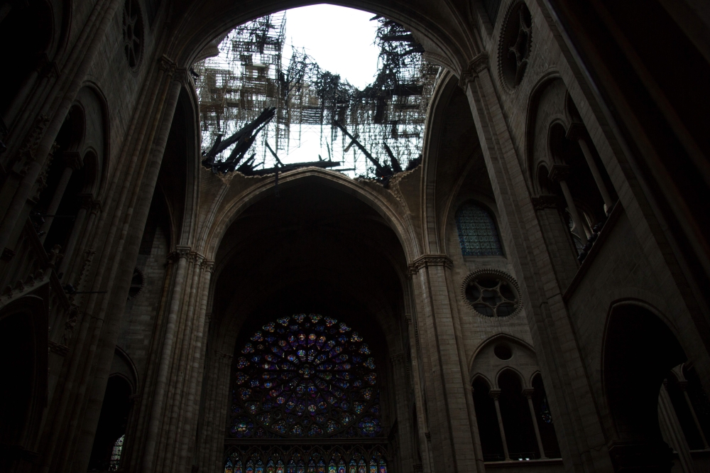 This photo shows one of the rose windows below the damaged roof of Notre-Dame-de Paris Cathedral in Paris on April 16, 2019, a day after a fire that devastated the building in the centre of the French capital. AFP / Amaury BLIN