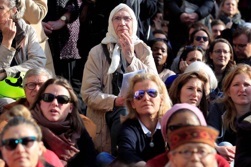 People gather outside the Saint Sulpice church during a mass two days after a massive fire devastated large parts of the gothic structure of Notre-Dame Cathedral in Paris, France, April 17, 2019. Reuters/Gonzalo Fuentes