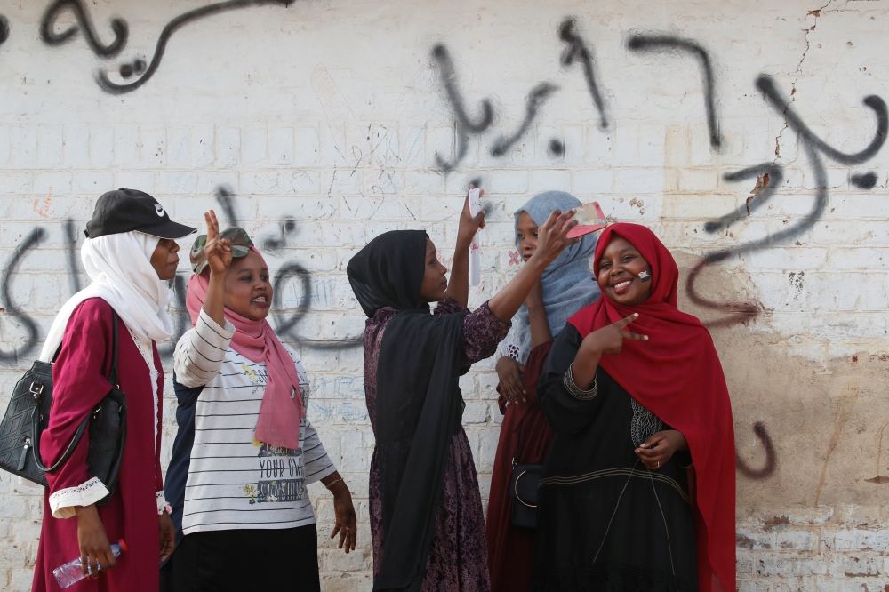 Sudanese demonstrators make victory signs and take selfies during a protest in front of the Defence Ministry in Khartoum, Sudan April 17, 2019. Reuters/Umit Bektas