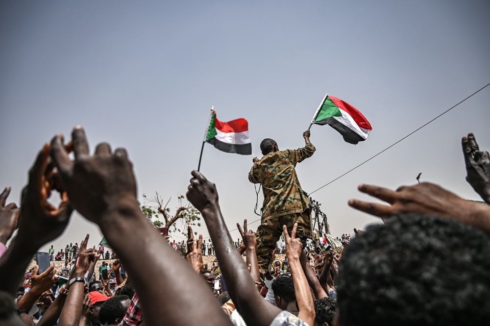 Sudanese protestors shout slogans as they carry a sudanese officer during a protest outside the army complex in the capital Khartoum on April 18, 2019.  AFP / OZAN KOSE
