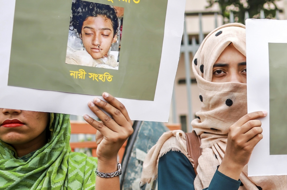 Bangladeshi women hold placards and photographs of schoolgirl Nusrat Jahan Rafi at a protest in Dhaka, following her murder by being set on fire after she had reported a sexual assault, on April 12, 2019. AFP / Sazzad Hossain 
