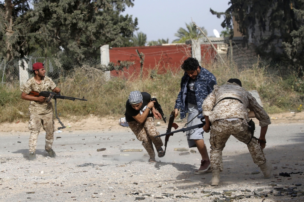 Libyan fighters loyal to the Government of National Accord (GNA) run as they fire their guns during clashes with forces loyal to strongman Khalifa Haftar south of the capital Tripoli's suburb of Ain Zara, on April 20, 2019.  AFP / Mahmud Turkia 
