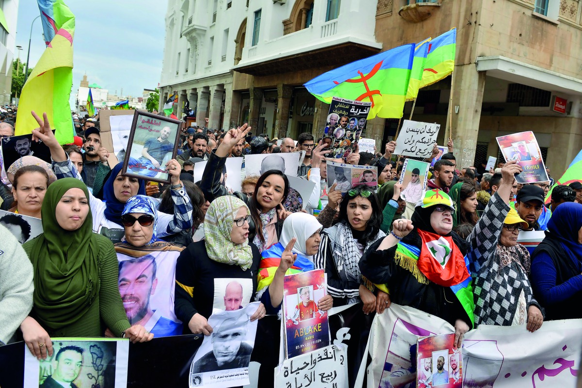 Moroccans shout slogans while waving the Berber, or Amazigh, flag during a demonstration against the court of appeal rulings on Al-Hirak al-Shaabi or 