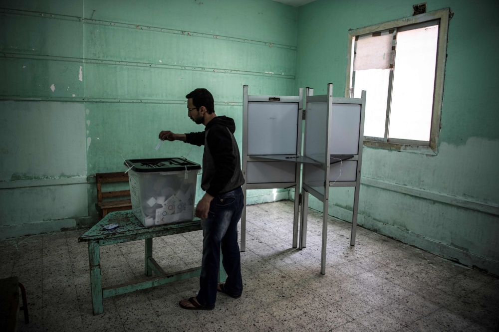 An Egyptian man casts his vote in a polling station during the third day of a referendum on constitutional amendments in Cairo on April 22, 2019.  AFP / Khaled Desouki 