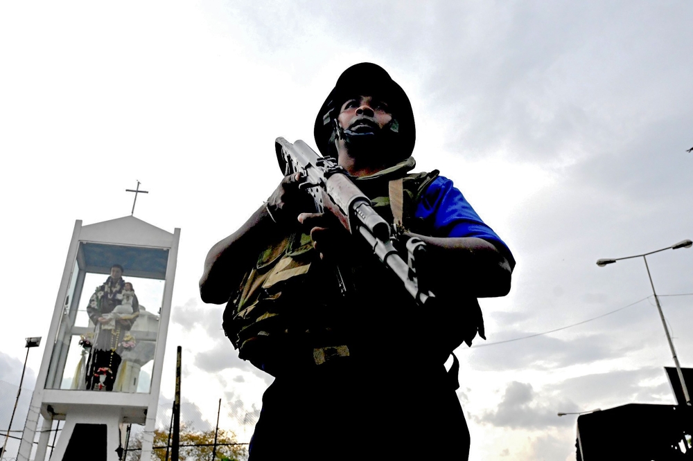 A Sri Lankan soldier stands guard near a car explosion after the police tried to defuse a bomb near St. Anthony's Shrine in Colombo on April 22, 2019, a day after the series of bomb blasts targeting churches and luxury hotels in Sri Lanka.  AFP / Jewel Sa