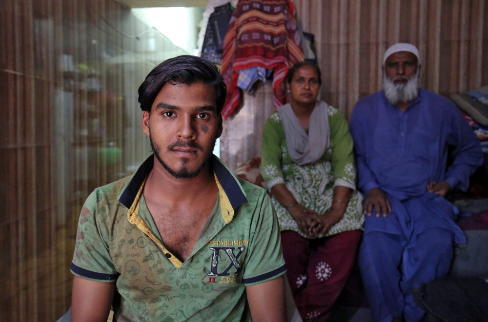 Mohammad Rafiq, 18, poses with his parents inside their house in Ahmedabad, India, April 17, 2019. Picture taken April 17, 2019. Reuters/Amit Dave
