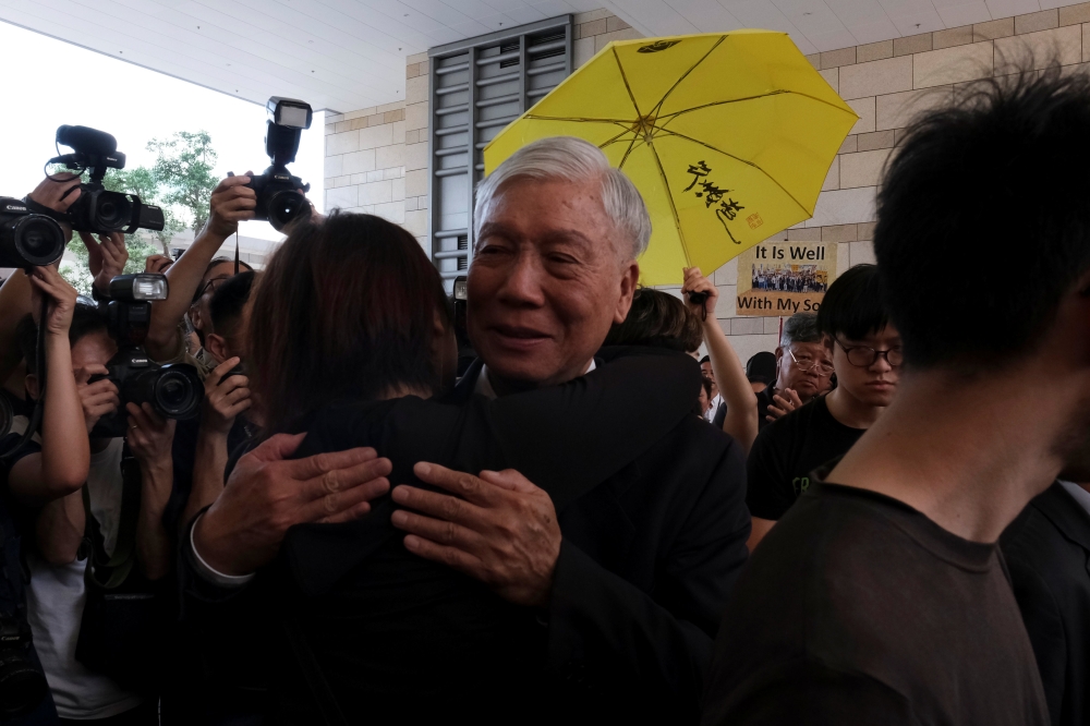 Occupy Central pro-democracy movement founder Chu Yiu-ming hugs a supporter after he had his suspended sentence on his involvement in the Occupy Central, also known as 