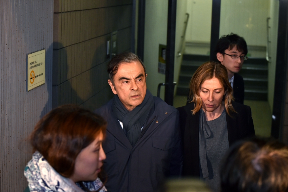 FILE PHOTO: Former Nissan Chairman Carlos Ghosn (2nd L) and his wife Carole (2nd R) leave the office of his lawyer in Tokyo.   AFP / Kazuhiro NOGI 