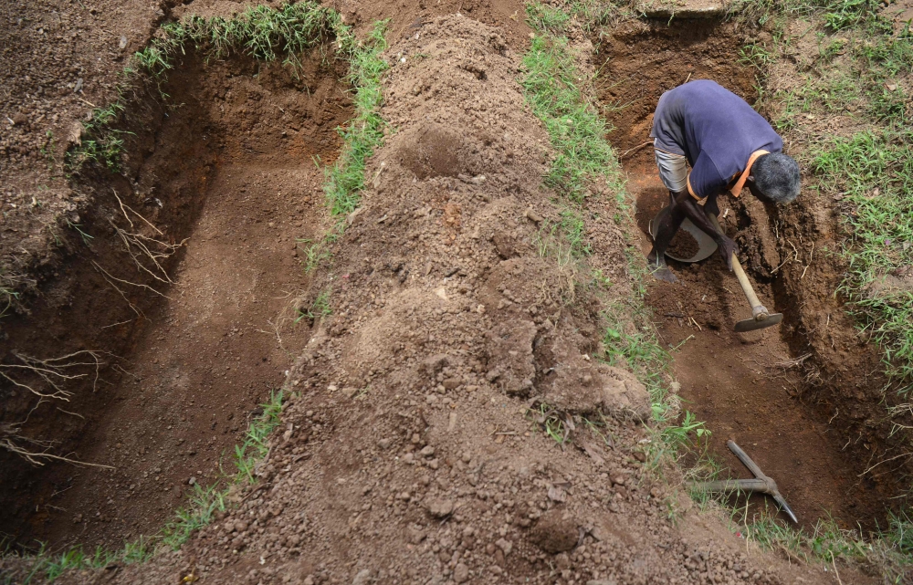 A cemetery worker digs a grave at Madampitiya cemetery in Colombo on April 23, 2019.  AFP / Lakruwan Wanniarachchi 
