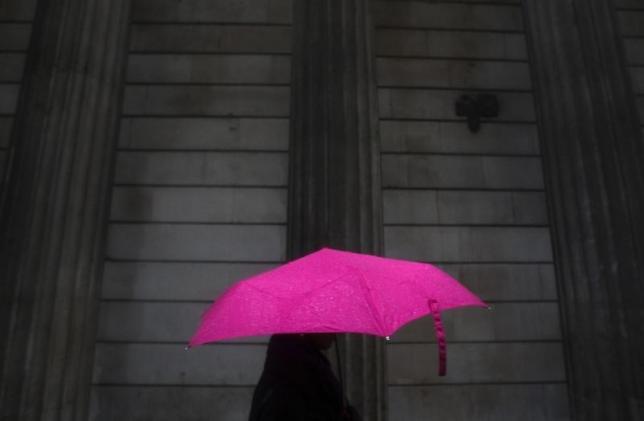 A woman carries an umbrella during a rain shower as she walks past the Bank of England in London, November 30, 2009. Reuters/Andrew Winning