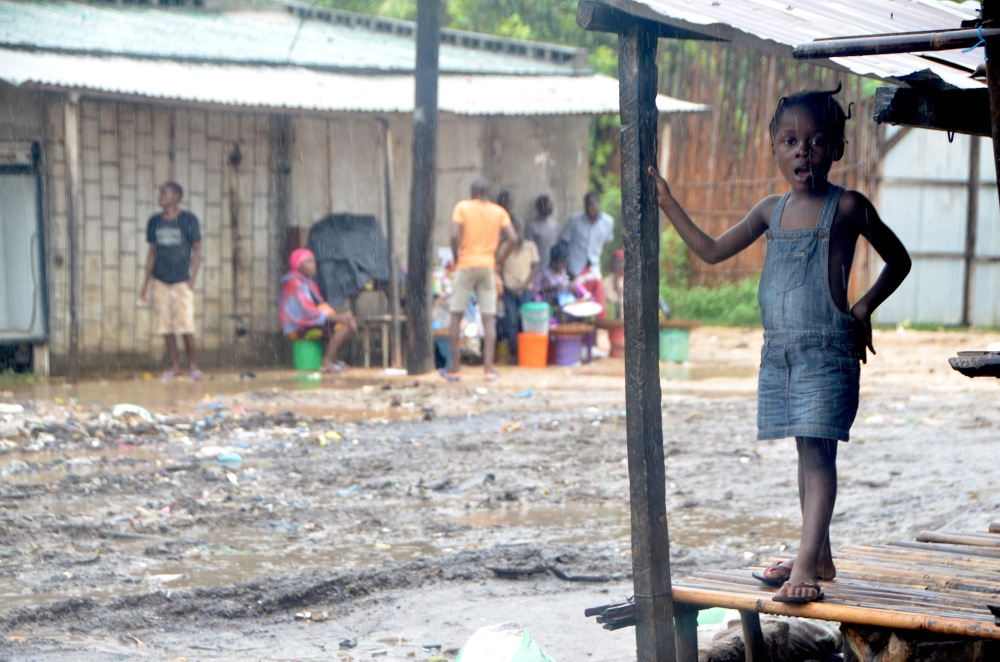 A little girl stands on the porch of her house in the Paquite district of Pemba on April 29, 2019, as Cyclone Kenneth hit northern Mozambique, killing 38 and destroying thousands of home.  AFP / EMIDIO JOZINE
