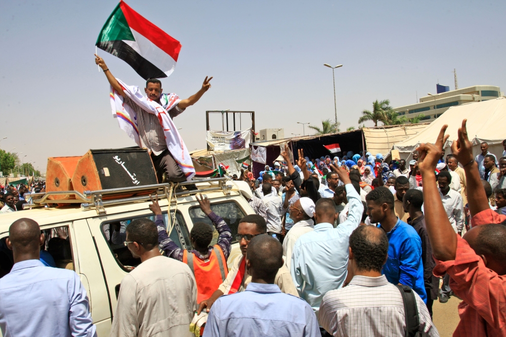 Sudanese protesters, waving national flags, take part in a sit-in outside the army headquarters in Khartoum on May 5, 2019.  AFP / ASHRAF SHAZLY
