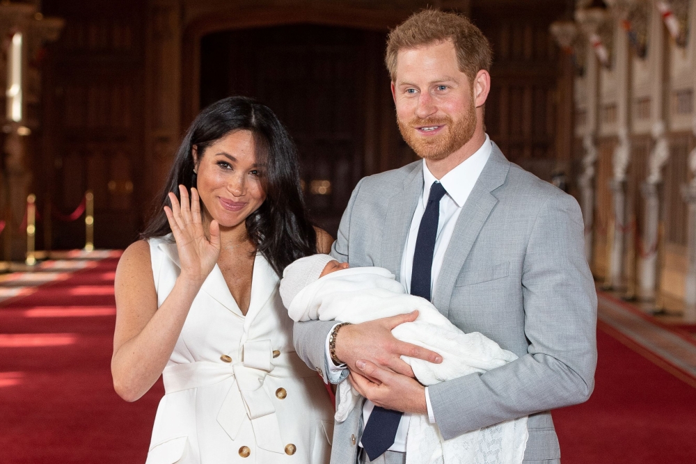 :Britain's Prince Harry, Duke of Sussex (R), and his wife Meghan, Duchess of Sussex, pose for a photo with their newborn baby son in St George's Hall at Windsor Castle in Windsor, west of London on May 8, 2019. (AFP / POOL / Dominic Lipinski)