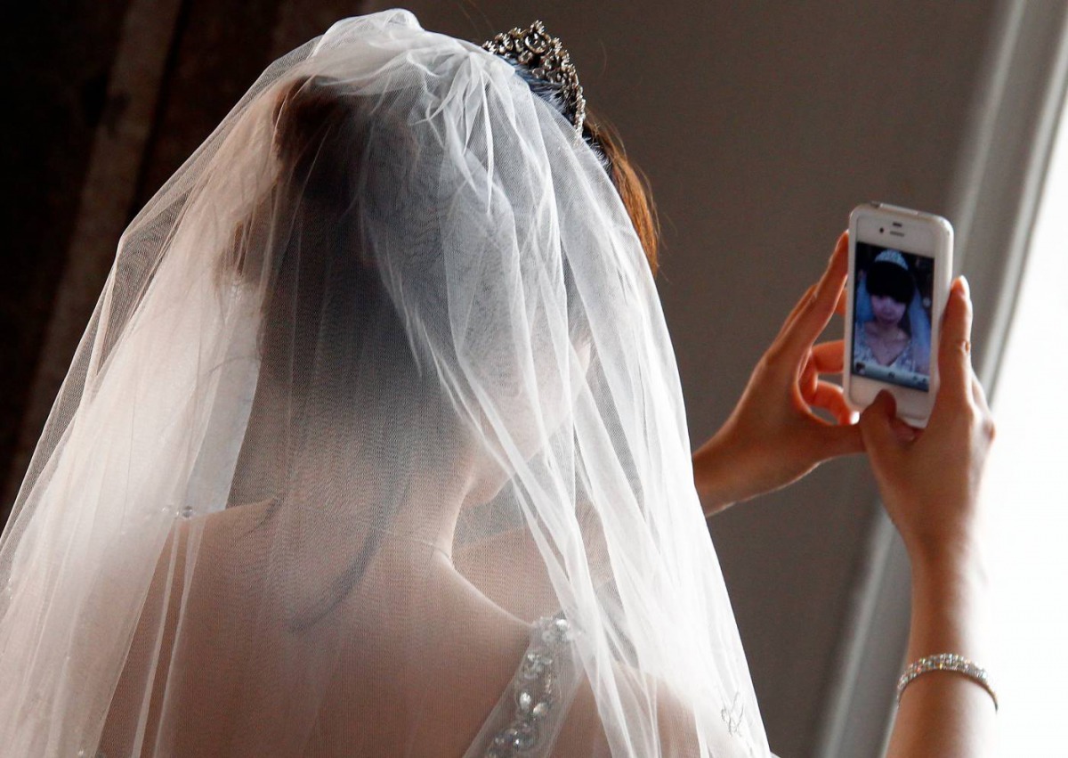A Chinese bride takes a self portrait before her symbolic wedding in Fuessen, May 31, 2012. Reuters/Michael Dalder
