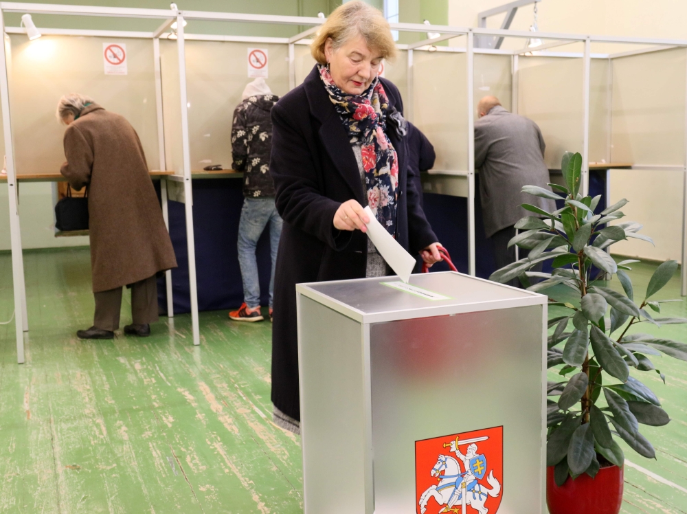 A voter casts her ballot during the first round of the presidential election at a polling station in Vilnius on May 12, 2019.   AFP / Petras Malukas