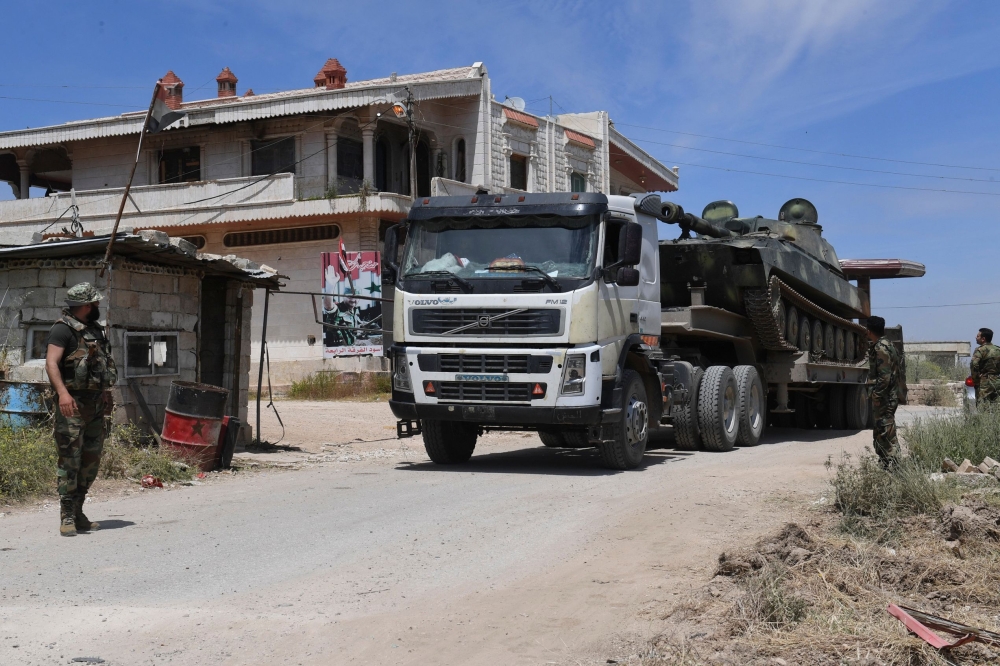Syrian army forces enter the town of Kafr Nabuda, about 40 kilometres north of Hama, on May 11, 2019. / AFP / George OURFALIAN