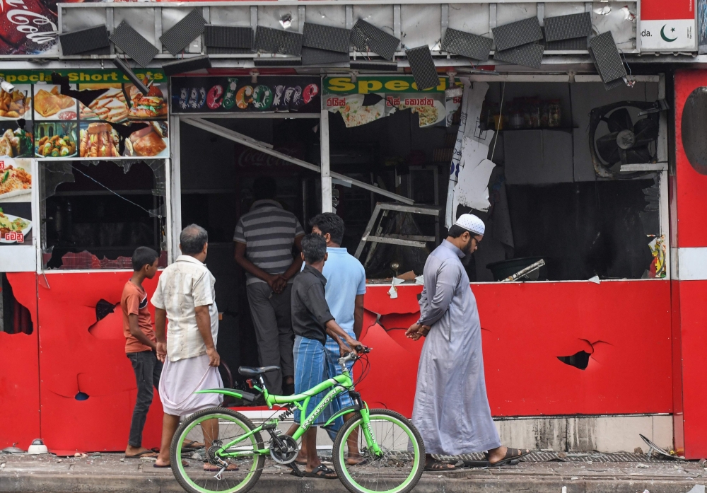 People view a damaged shop after a mob attack in Minuwangoda on May 14, 2019. (AFP / LAKRUWAN WANNIARACHCHI)
 