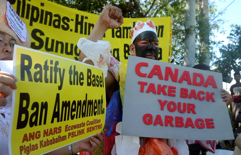 This file photo taken on September 9, 2015, shows environmental activists rallying outside the Philippine Senate in Manila to demand that scores of containers filled with household rubbish be shipped back to Canada. AFP / JAY DIRECTO