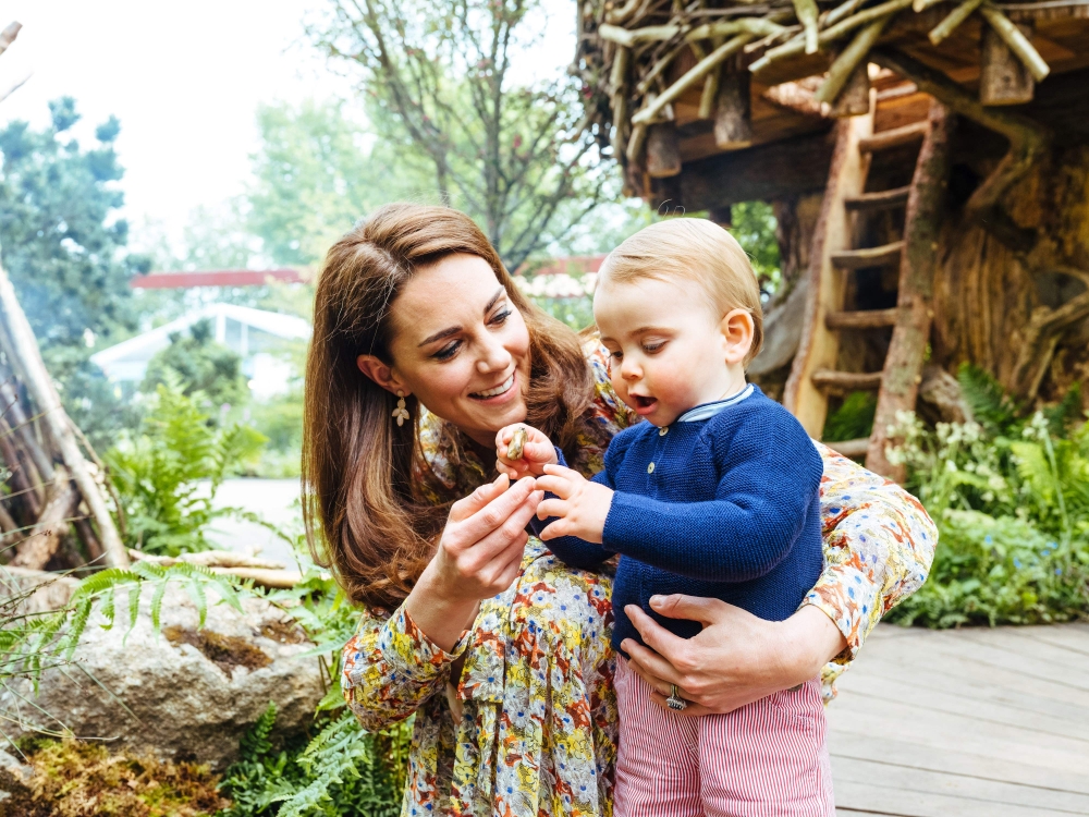 A picture released by Kensington Palace on May 19, 2019 shows Britain's Catherine, Duchess of Cambridge standing with Prince Louis in the Adam White and Andree Davies co-designed 'Back to Nature' garden ahead of the RHS Chelsea Flower Show in London. AFP 