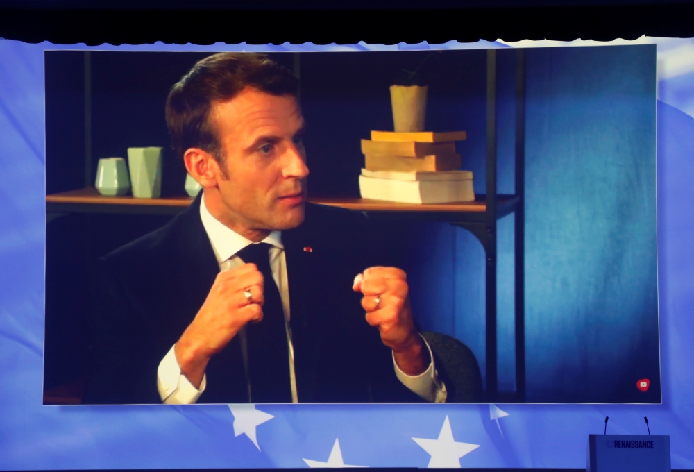 French President Emmanuel Macron appears on a screen during a live chat on Youtube and Facebook as La Republique En Marche (Republic on the Move) holds the last European election rally in Paris, France May 24, 2019. REUTERS/Charles Platiau
