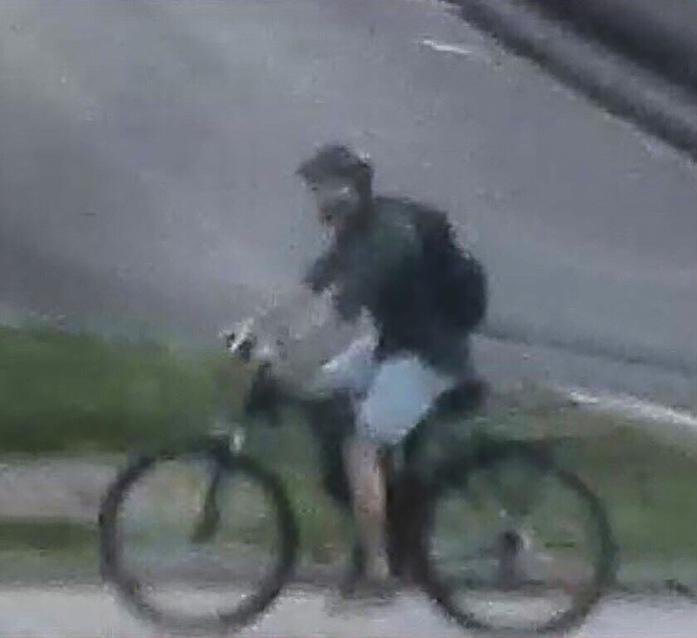 This handout video frame grab from a surveillance camera made available by the French National Police on their Twitter account on May 25, 2019 shows a male riding a mountain bike in the vicinity of a suspect package bomb blast that took place along a pede