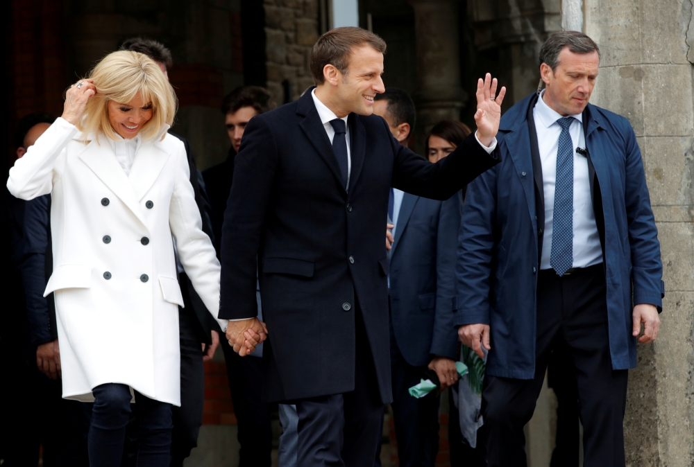 FILE PHOTO: French President Emmanuel Macron and his wife Brigitte leave after casting their ballots during the European Parliament Elections, in Le Touquet, France, May 26, 2019. REUTERS/Philippe Wojazer
