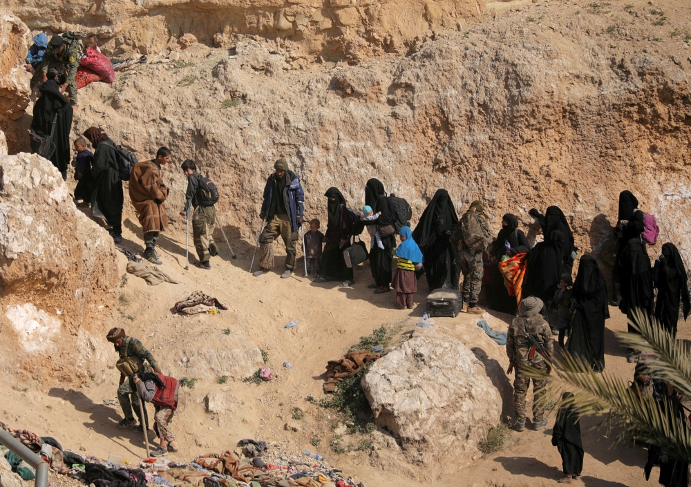 FILE PHOTO: Islamic state fighters and their families walk as they surrender in the village of Baghouz, Deir Al Zor province, Syria March 12, 2019. REUTERS/Rodi Said