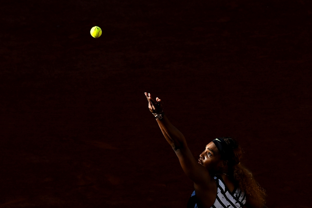 Serena Williams of the US eyes the ball as she serves the ball to Sofia Kenin of the US during their women's singles third round match on day seven of The Roland Garros 2019 French Open tennis tournament in Paris on June 1, 2019. / AFP / Philippe LOPEZ