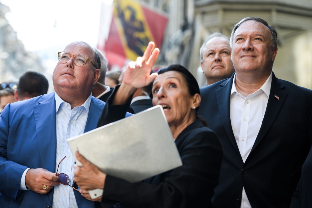 US Ambassador to Switzerland Edward McMullen, tour guide Denise O’Gorman and US Secretary of State Mike Pompeo face the clock tower (Zytglogge) during a visit on June 1, 2019 in the Swiss capital Bern.  AFP / Fabrice Coffrini 