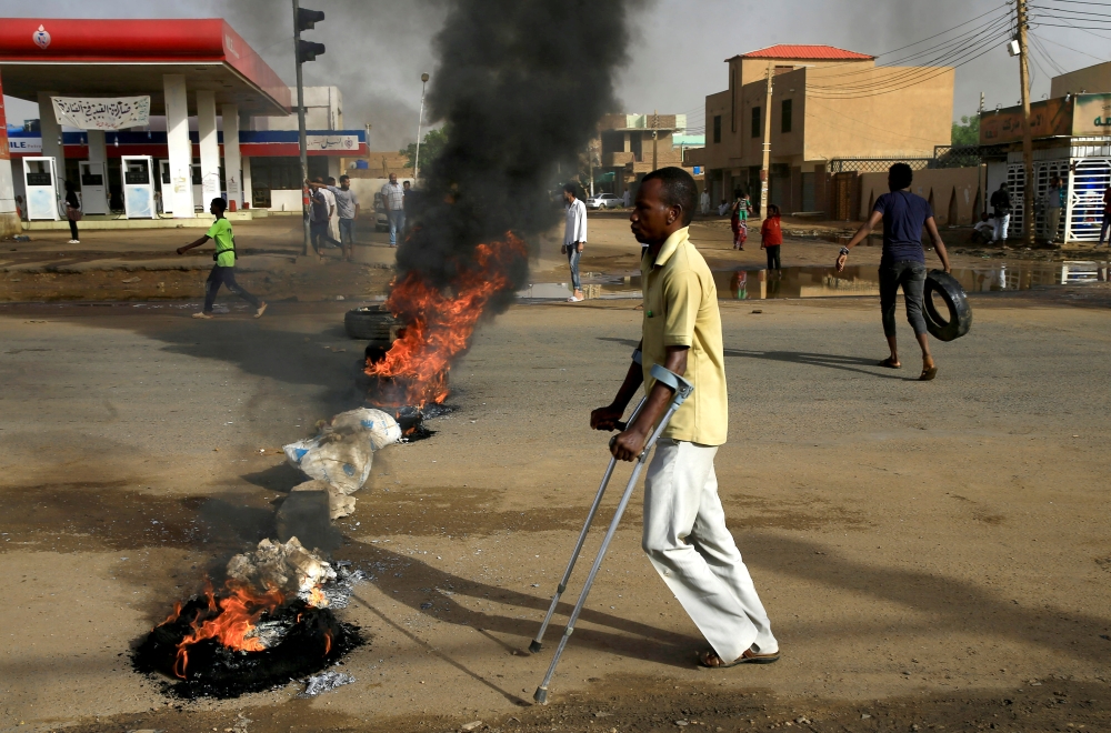 A disabled man walks past a barricade erected by Sudanese protesters along a street, demanding that the country's Transitional Military Council hand over power to civilians, in Khartoum, Sudan June 3, 2019. REUTERS/Stringer TPX IMAGES OF THE DAY