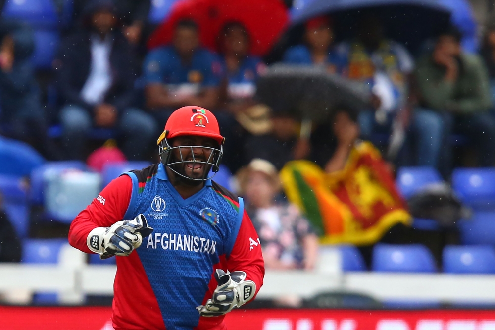 Afghanistan's Mohammad Shahzad celebrates Sri Lanka's Kusal Perera's dismissal for 78 during the 2019 Cricket World Cup group stage match between Afghanistan and Sri Lanka at Sophia Gardens stadium in Cardiff, south Wales, on June 4, 2019.  AFP / Geoff Ca