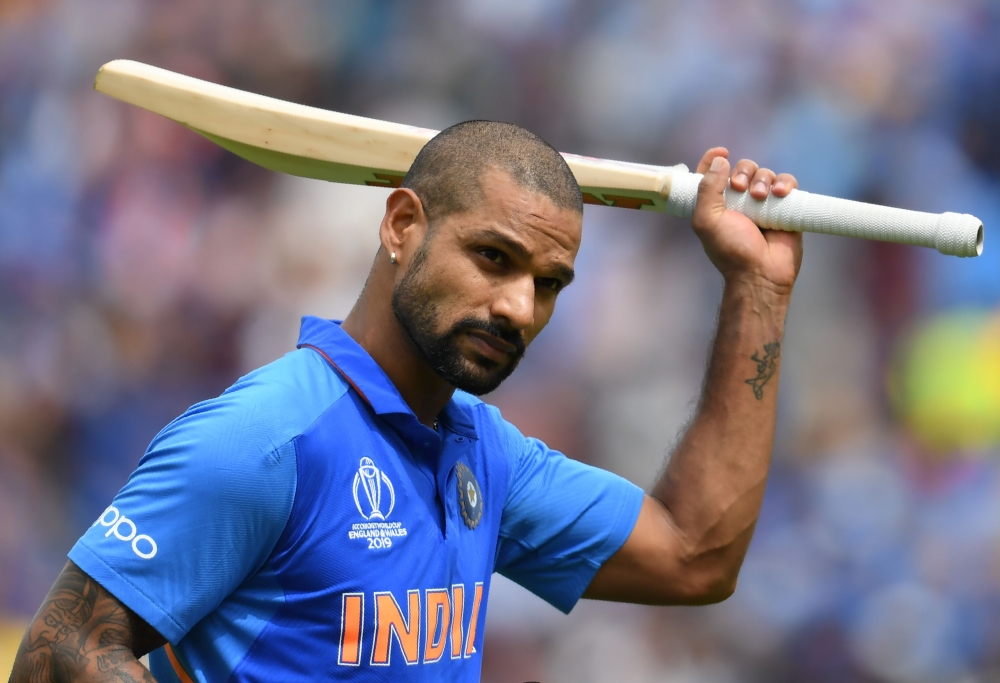 India's Shikhar Dhawan raises his bat to the crowd as he walks back to the pavilion after his dismissal during the 2019 Cricket World Cup group stage match between India and Australia at The Oval in London on June 9, 2019. AFP / Dibyangshu Sarkar 