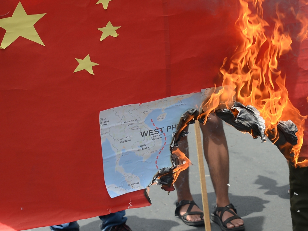 Activists burn a mock Chinese flag with a map of the South China sea during a protest in front of the Chinese consulate in Manila on June 12, 2019, against the Asian superpower's growing sway in the Philippines and as tensions rise over Beijing's presence