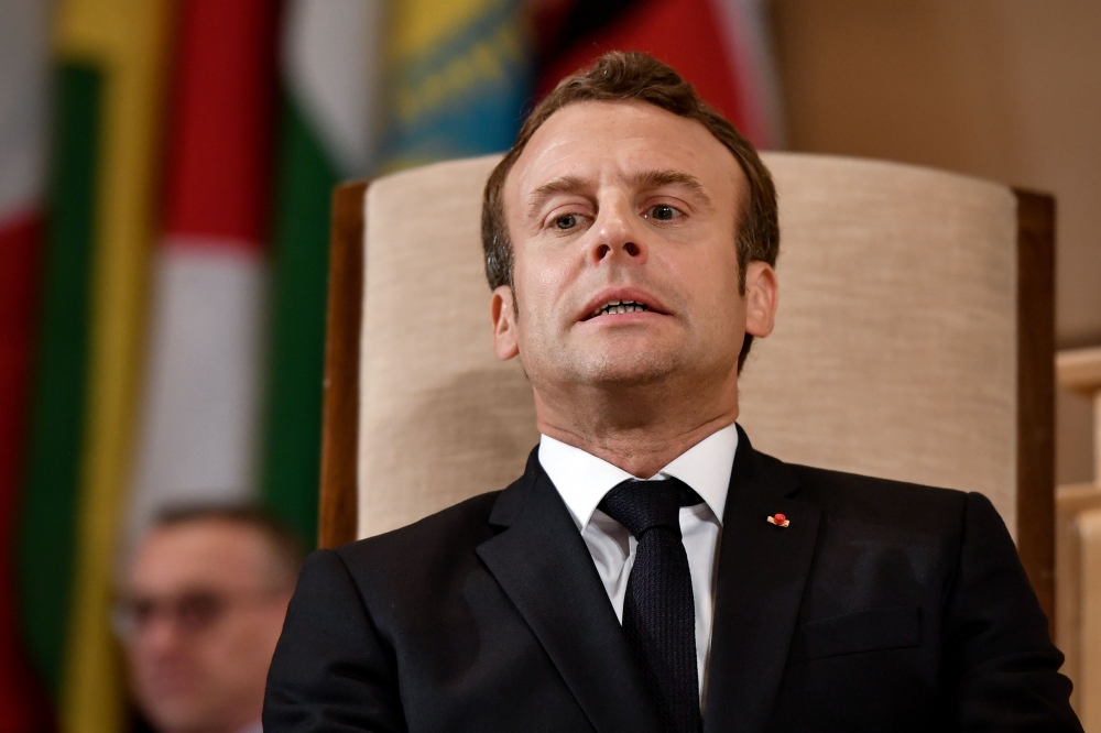 French President Emmanuel Macron grimaces before his speech before the International Labour Organization (ILO) Conference on June 11, 2019 in Geneva. / AFP / FABRICE COFFRINI