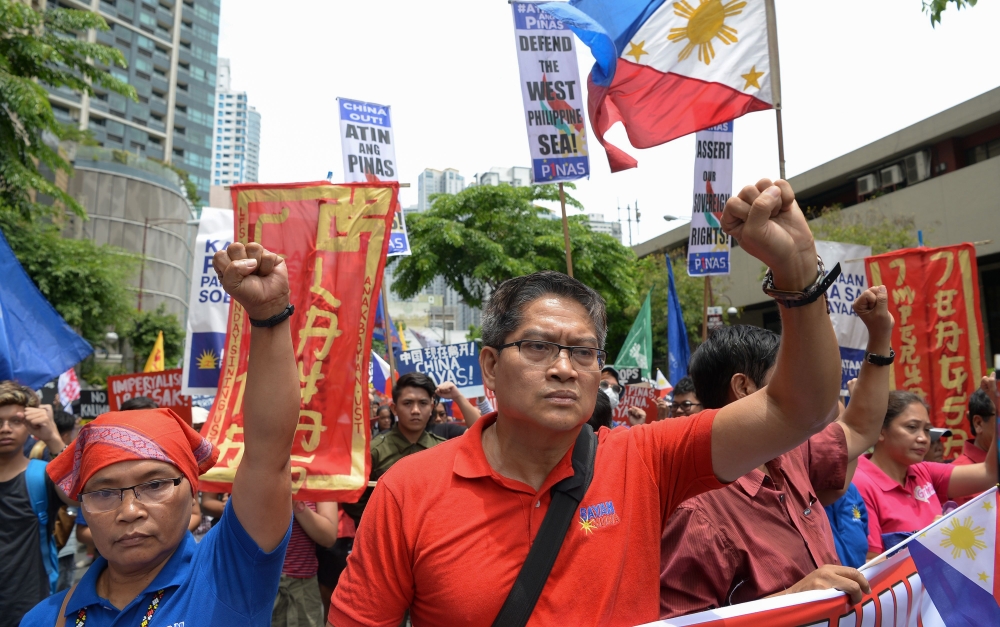 Activists and progressive legislators raise clinched fists during a protest in front of the Chinese consulate in Manila on June 12, 2019, against the Asian superpower's growing sway in the Philippines and as tensions rise over Beijing's presence in the di